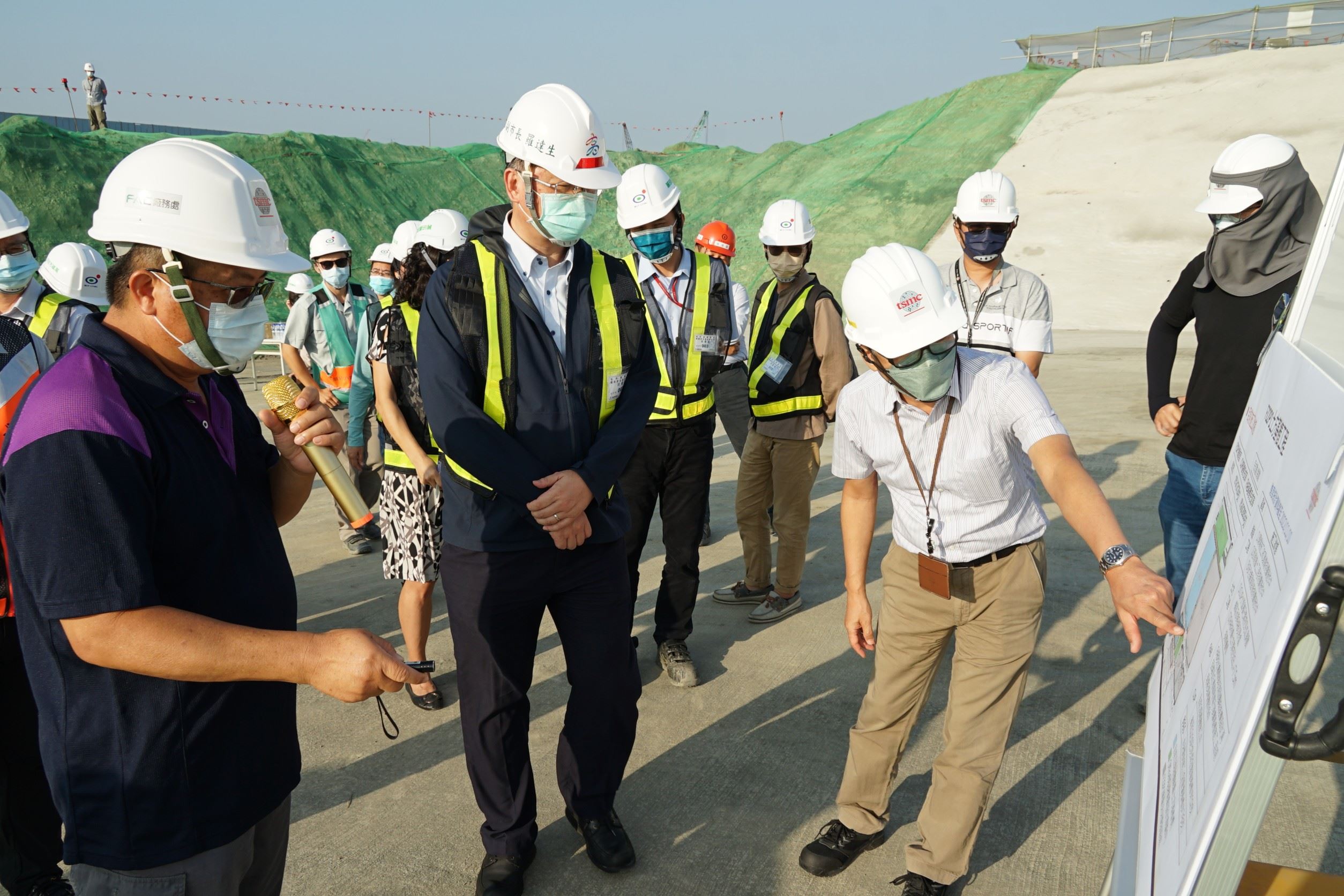 圖3：台積電高雄廠資深經理李明利（前右一）在施工現場向副市長羅達生（中）說明工廠基樁施工進度.jpg
